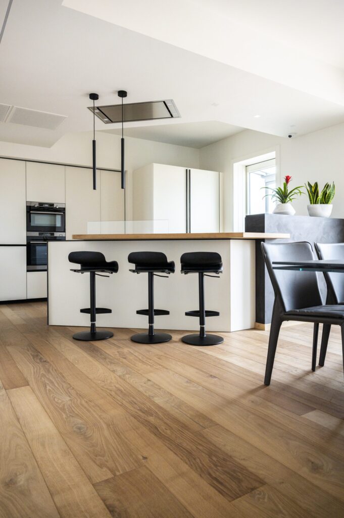 Ettore, pavimento e piano bancone cucina in rovere bio in un ambiente moderno.