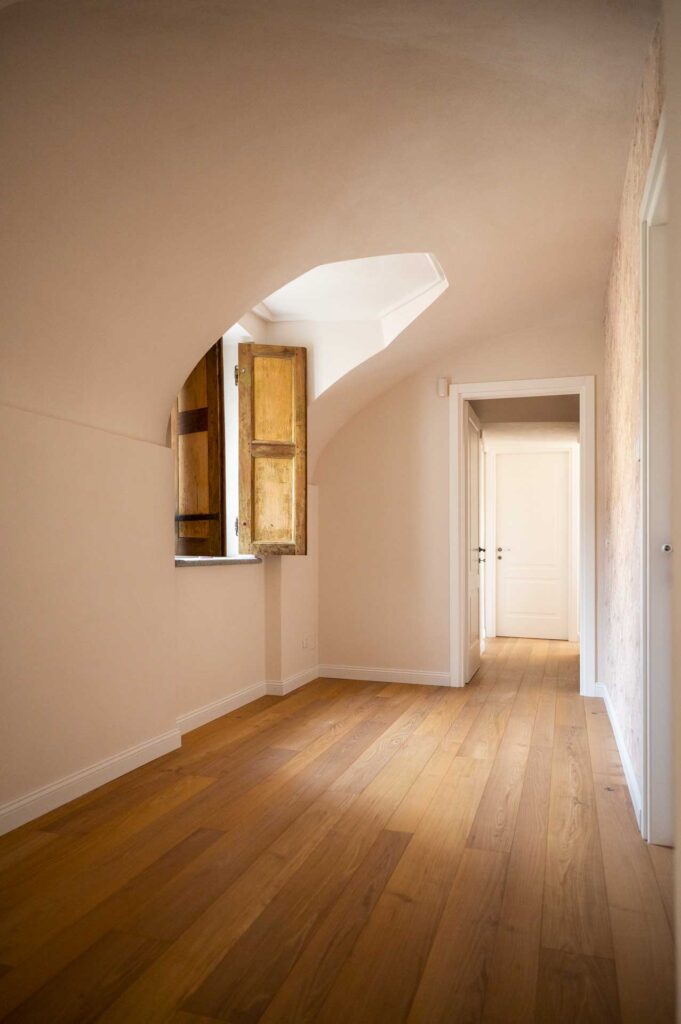 Aiace, pavimento in acacia bio in un ambiente dallo stile classico, con scuri in legno e carta da parati.