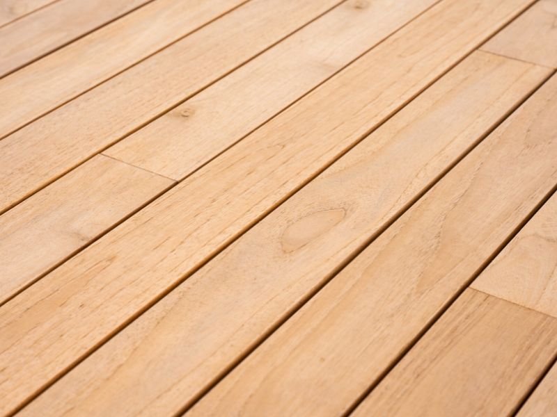 Primo piano delle venature del decking in teak per esterni, evidenziando la finitura naturale e la resistenza agli agenti atmosferici.
