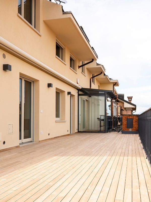 Terrazzo con pavimentazione in decking di teak e dehor in vetro.